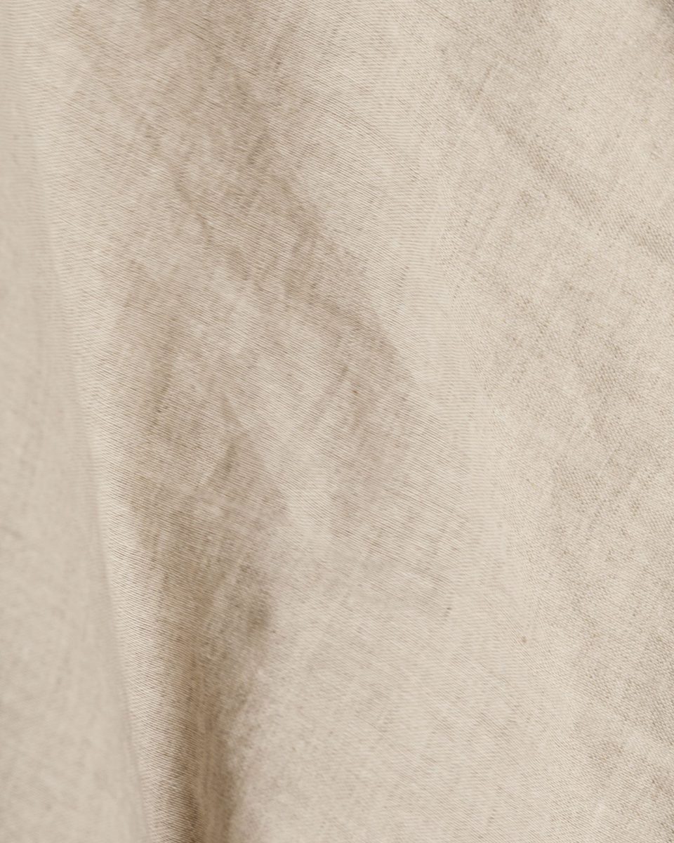 A close view of a smooth beige cotton cloth with soft folds